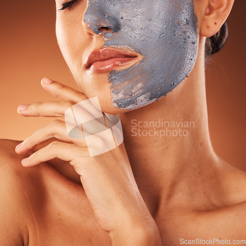 Image of Woman, face mask or skincare mud facial on orange studio background in self care, dermatology or acne treatment. Zoom, beauty model or cream product for cleaning, healthcare glow or collagen wellness