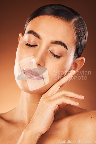 Image of Skincare, facial and hands of woman on face in studio for beauty, makeup and hygiene wellness on orange background. Hand, girl and model in India for cosmetic, product and smooth skin care mock up