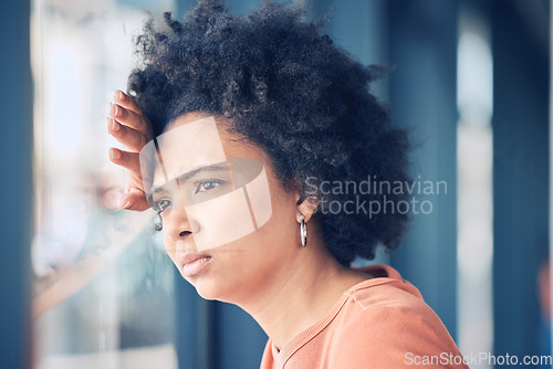 Image of Sad, lonely and depressed woman at window waiting, thinking and looking outside. Mental health, depression and anxiety, black woman with problem, stress or debt on her mind and life crisis feelings.