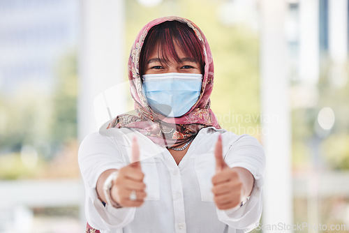 Image of Business woman, covid and thumbs up for workplace compliance, corona virus health policy and muslim in face mask. Islamic employee portrait with ok, like and thank you sign for covid 19 safety goals