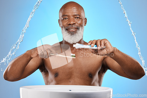 Image of Water splash, dental and senior black man with a toothbrush and toothpaste for cleaning his teeth in studio. Face, portrait and elderly person brushing teeth or mouth on bathroom sink for self care