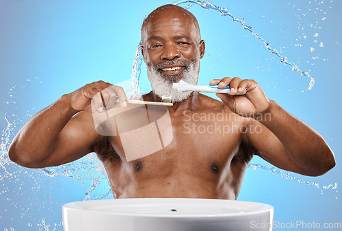 Image of Brushing teeth, bamboo and black man in studio with toothpaste for dental or mouth care product promotion on blue mockup. Senior black man portrait, eco friendly or wood toothbrush and water splash