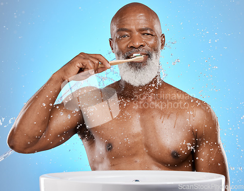 Image of Dental, brushing teeth and black man with toothbrush for teeth, cleaning with toothpaste for fresh breath and healthy gums against blue background. Water, splash and hygiene with dental care and oral