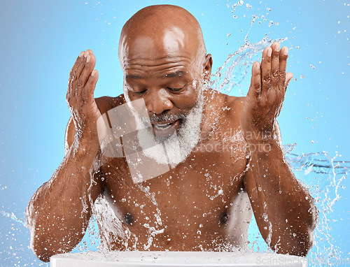 Image of Man, mature or water splash in face skincare, morning grooming routine or facial cleaning dermatology and healthcare wellness. Person washing, hygiene or self care for black model on blue background