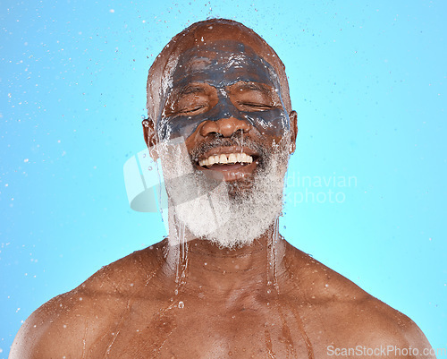 Image of Skincare, water and black man with mask for facial on blue background in studio for wellness, spa and cleanse. Dermatology, cleaning and senior male with face mask, skin treatment and water splash