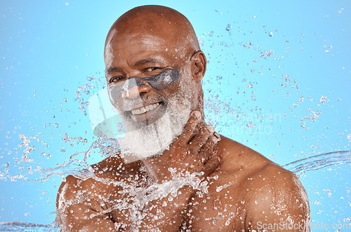 Image of Skincare, water and portrait of black man with facial on blue background in studio for wellness, spa and cleanse. Cleaning, beauty and senior male with water splash, facial mask and luxury treatment