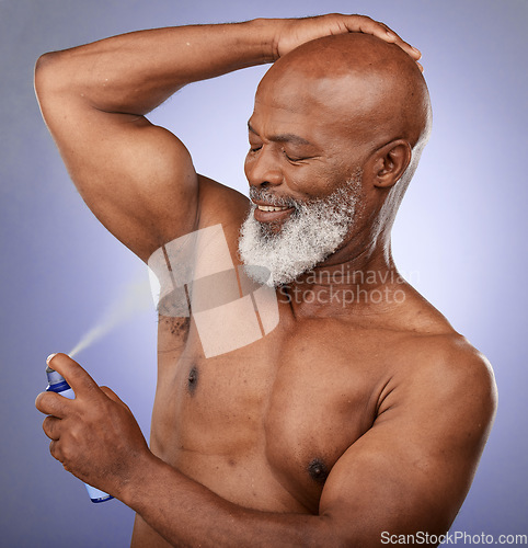 Image of Deodorant, grooming and senior black man with self care, hygiene beauty and spray against a purple studio background. Perfume, clean armpit and elderly African model with product for fresh body