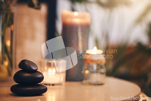 Image of Stone, candle and spa with a still life objects on a table in a wellness center for aromatherapy to relax. Background, rock and luxury with stones and candles in a health salon for stress relief