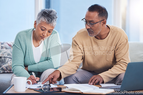 Image of Senior black couple, taxes and home with laptop, documents or focus in home for family finance. Elderly, woman and man with computer, tablet or notebook in audit, budget or planning on lounge sofa