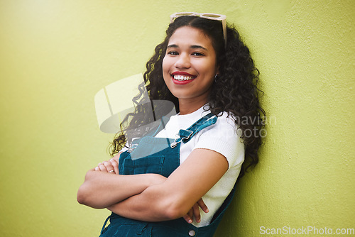 Image of Girl smile with fashion glasses in hair, show expression of beauty, happiness and confidence. Portrait of beautiful latino woman, happy with arms crossed against green background or wall in the city