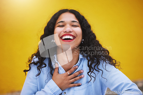 Image of Happy, smile and fun with a woman laughing and joking in studio against a yellow background. Carefree, joy and humor with an attractive young female standing inside on a bright and colorful wall