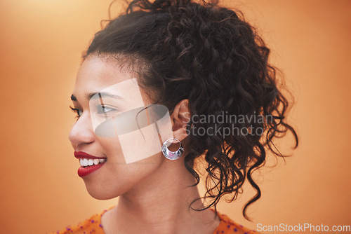 Image of Face of happy young hispanic woman thinking of ideas, beauty and gen z fashion against an orange color studio background. Smile, youth and happiness of confident girl with curly hair, vision and joy