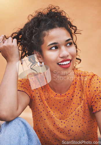 Image of Young black woman, stylish fashion tshirt thinking and hand in trendy curly hair. Portrait of happiness, nostalgia and cool urban style. Glowing skin, sitting on the floor in jeans and happy smile