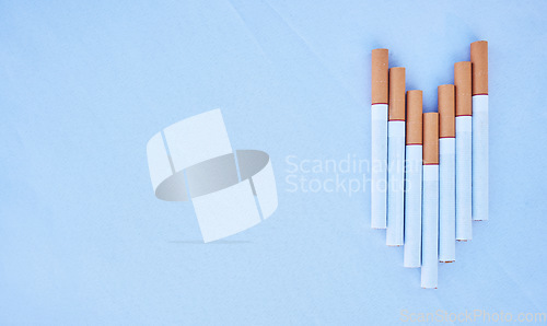 Image of Cigarettes in a studio against a blue background mockup for cancer, toxic and addiction awareness. Cigarette, tobacco business and industry advertising for smoke, marketing and smoking market