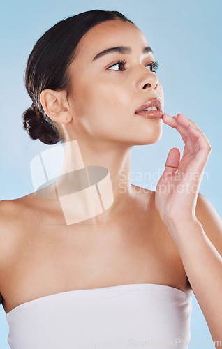 Image of Wellness, cosmetic and beauty skincare with woman lips and face posing isolated in studio against a blue background. Attractive female model looking confident and healthy with her daily skin routine