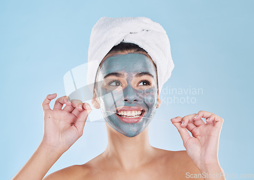 Image of Skincare mask, hair care or dental floss in grooming, busy beauty and studio wellness on blue background. Smile, happy face or relax woman with mud product facial and cleaning teeth for healthy gums