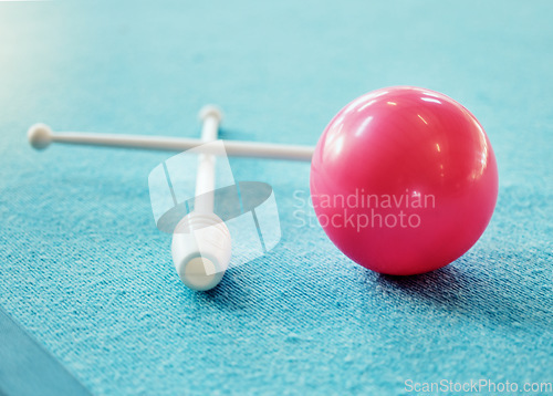 Image of A red ball on the floor on a blue carpet with gymnastics club. Gym, fitness and training exercise equipment for rhythmic gymnastics isolated on blue background. Mockup for sports and dance athlete