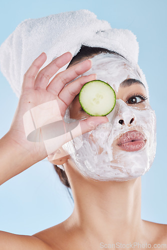 Image of Beauty skincare, skin wellness and face mask with cucumber against a blue mockup studio background. Portrait of model pouting lips, vegetable for health and cosmetic person with healthy food