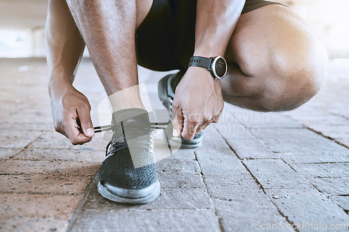 Image of Shoes, fitness and exercise with a sports man tying his laces for a cardio and endurance workout in the city. Training, running or exercise and an athlete with a motivation for health and wellness