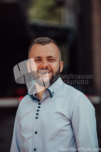 Image of A portrait of a modern man, exuding confidence and style, against an outdoor backdrop, showcasing his charisma and fashionable demeanor.