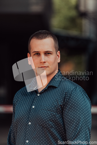 Image of A portrait of a modern man, exuding confidence and style, against an outdoor backdrop, showcasing his charisma and fashionable demeanor.