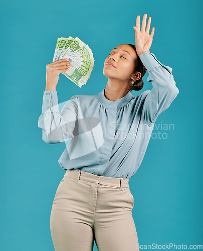 Image of Woman showing off money, looking rich with cash prize and winning the lottery while standing against a blue studio background. Female billionaire holding bank notes and looking confident with salary