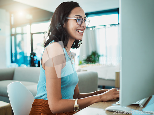 Image of Social media agent with computer browsing online, typing and replying to customer or client emails in home office. Motivated, inspired and smiling creative business woman planning marketing strategy