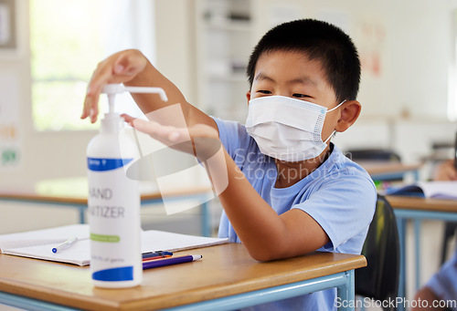 Image of Covid, hand sanitizer and school student with mask cleaning, protecting and staying safe in education classroom. Small, little and cute asian boy in learning in study class preventing spread of virus