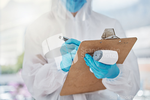 Image of Doctor writing covid safety report with laser thermometer for fever symptom of virus, sick or illness with patient information notes at mobile vaccine clinic. Healthcare worker for medical wellness