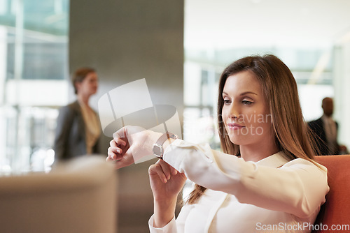 Image of Time, watch and business woman in a corporate lobby, waiting and working at a company. Management, executive and impatient manager with a smart watch check at a professional lounge for networking