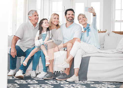 Image of Happy family, selfie and girl relax with parents, grandparents and smartphone on sofa in a living room, happy and bonding. Family, phone and multi generations smile for picture while sitting on couch