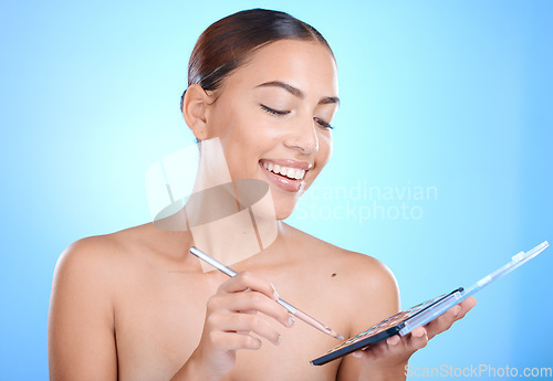 Image of Beauty, makeup and woman in studio for eyes, color and creative face art against blue background mockup. Model girl and eyeshadow palette for daily routine, glamour and luxury self care with mock up