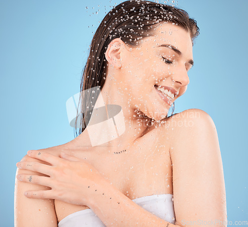 Image of Beauty, skincare and water with woman in shower for cleaning, hygiene and relax. Self care, wellness and cosmetics with girl model for product, facial and hydration in blue background studio