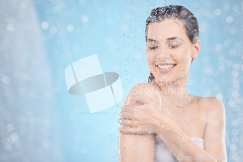 Image of Cleaning, shower and woman with water in studio on blue background for beauty, wellness and body care. Spa hydration, skincare and happy girl washing for self care, health and hygiene in water drops