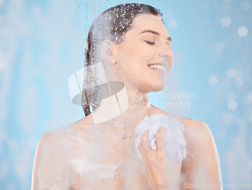 Image of Water, soap and skincare with woman in shower for beauty, self care and hygiene routine. Relax, luxury and spa with girl model and sponge for cosmetics, salon or cleaning in blue background in studio