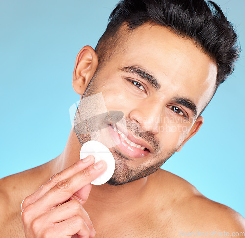 Image of Cotton, skincare and man in studio for face glow, shine and beauty product promotion, marketing or advertising benefits. Happy portrait, skin care model and facial cleaning wipe in dermatology health