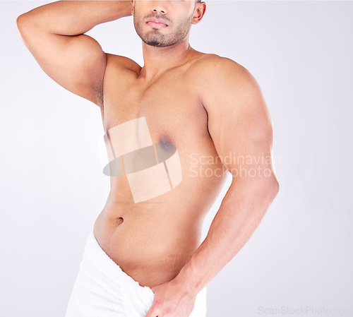 Image of Fitness, health and man with muscles in a studio for motivation, exercise and wellness in a towel. Strength, muscular athlete and strong male bodybuilder posing by a gray background after a workout.