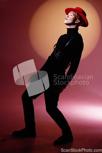 Image of Man, fashion and pose of an aesthetic, stylish male model posing on a red studio background. Artistic, creative and trendy guy with fashionable or luxury clothing and confidence on a studio backdrop