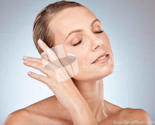 Image of Face, skincare or woman in a studio with cream for acne, anti aging or dermatology with sunscreen or mockup. Relax, product and model with facial lotion, natural makeup or foundation beauty cosmetics