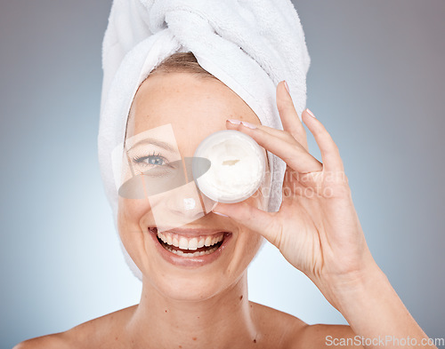 Image of Woman, face or skincare cream in grooming routine, healthcare wellness or collagen treatment on gray studio background. Portrait, happy smile or beauty model or eye care product in Canada dermatology