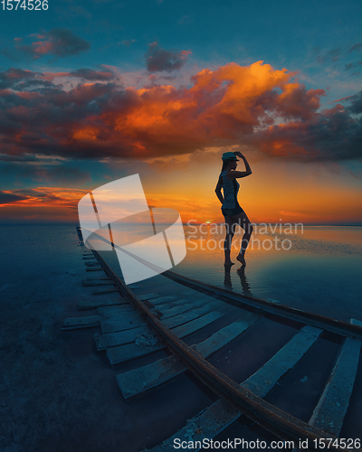 Image of Woman at beauty sunset on salty lake