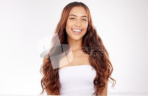 Image of Beauty, hair care and portrait of a happy woman in studio for a keratin, brazilian or botox treatment. Hair, wellness and girl model with long, shiny and curly hair style isolated by white background