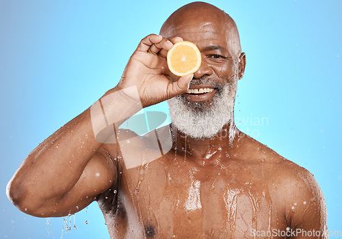 Image of Man face, fruit and water splash in skincare grooming, Nigeria healthcare wellness or vitamin c treatment on blue background studio. Portrait, happy smile and black model lemon in mature wet cleaning