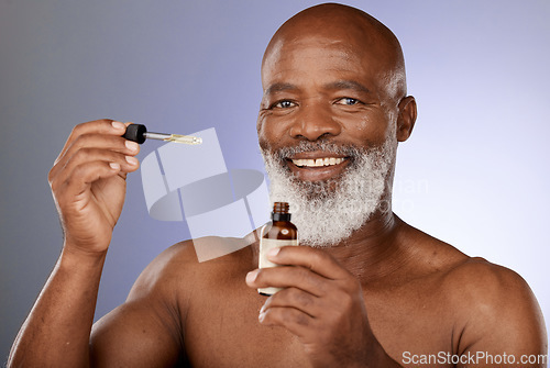 Image of Portrait, skincare and black man with oil serum cosmetics for acne, wrinkles or anti aging protection in studio. Face, senior or old man marketing an essential oil bottle or natural luxury product