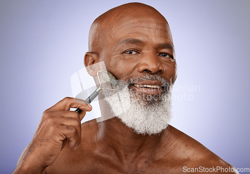 Image of Skincare, face roller and old man facial massage with gua sha stone for glowing healthy skin. Wellness, dermatology and relax, portrait of black man with jade roller for anti aging routine in studio.