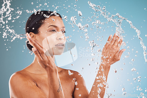 Image of Beauty, skincare and black woman with splash of water for cleaning, hygiene and body care routine. Self care, wellness and healthy skin of model thinking with water splash in blue studio.