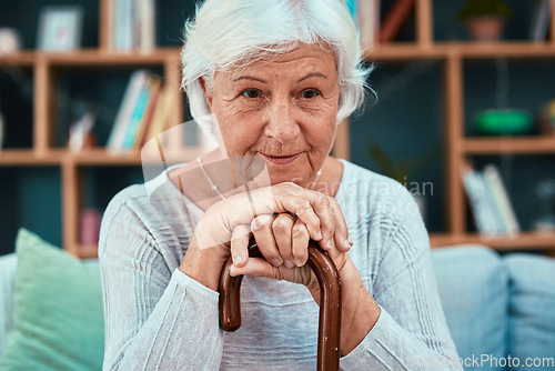 Image of Thinking, cane and retirement with a senior woman sitting on a sofa in the living room of her home alone. Idea, disability and walking stick with a mature female pensioner in her house to relax