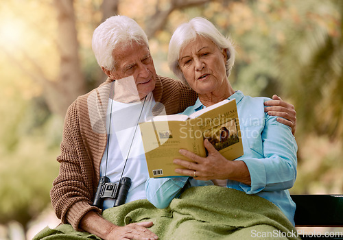 Image of Park, senior and couple reading a book, relaxing and bonding outdoors with blanket. Love, retirement and elderly man and woman studying literature, story or novel and enjoying quality time together.