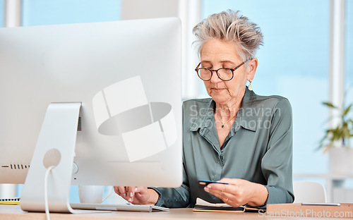 Image of Business woman, credit card and computer with banking, online shopping and payment for bills on internet in a office. Senior woman, ecommerce and transfer money on pc at desk at her job and web app