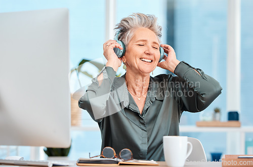 Image of Office music, relax and business woman with audio headphones, podcast and streaming radio in an office at work. Worker freedom, corporate smile and senior employee listening to a song on company wifi